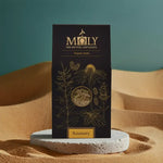 Eine Moly Verpackung mit Rosmarin bio auf einem Stein auf Sand.