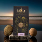 Eine Moly Verpackung mit Thymian bio auf einem Stein am Strand bei Sonnenuntergang.